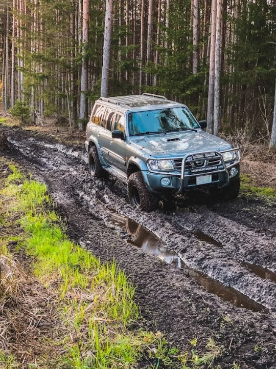 Сірий Nissan Patrol долає багнюку на лісовій off-road дорозі в Карпатах