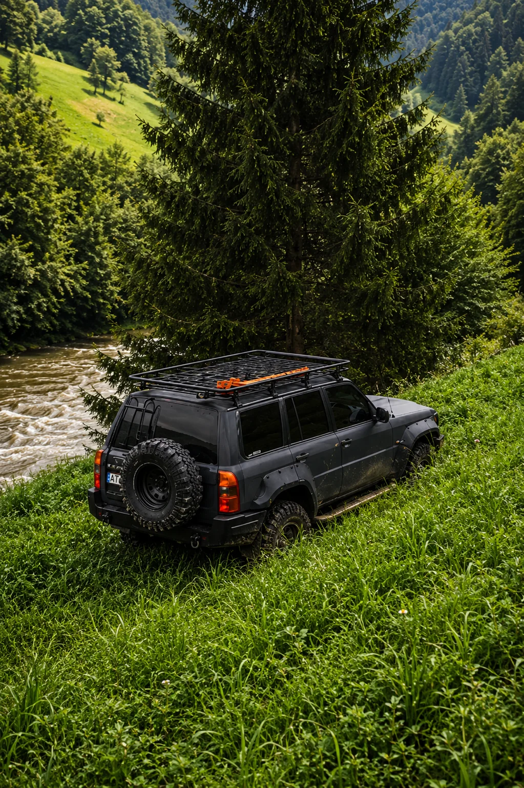 Чорний позашляховик Nissan Patrol біля гірської річки в Карпатах